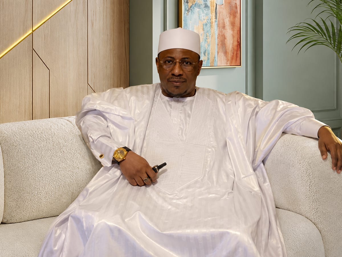 Le Professeur Karamba, en boubou blanc, assis dans son salon de consultation